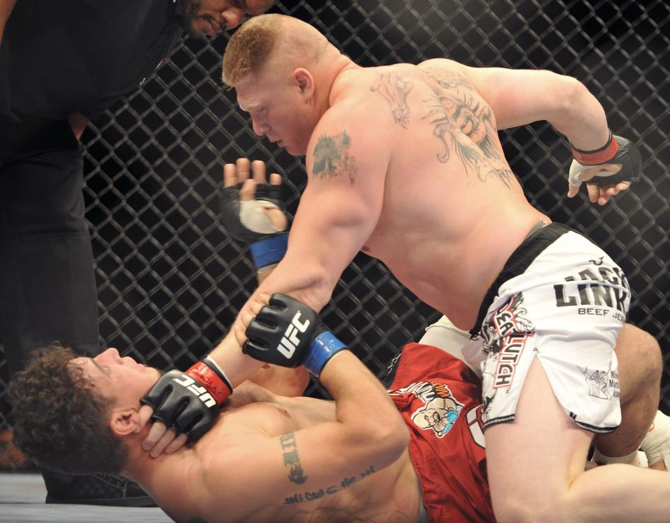 Brock Lesnar (top) puts the finishing touches on Frank Mir in their heavyweight title bout at UFC 100. (Getty Images)