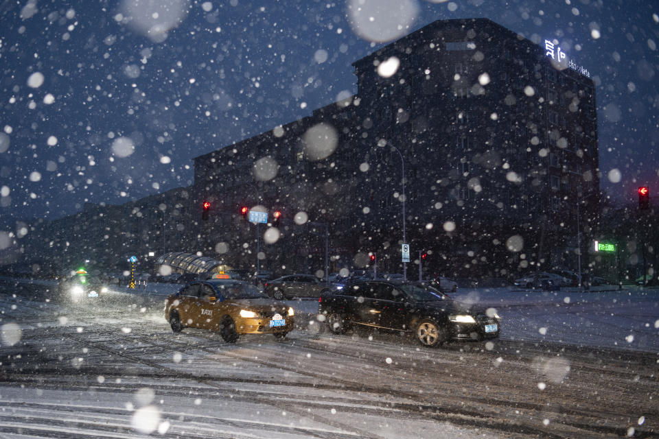 In this photo released by Xinhua News Agency, vehicles drive in the snow in Xiangfang District of Harbin, capital city of northeast China's Heilongjiang Province, on Monday, Nov. 6, 2023. Heavy snow blanketed swaths of China's northeastern region, shutting schools and halting transportation in the first major snowstorm of the season. (Xie Jianfei/Xinhua via AP)