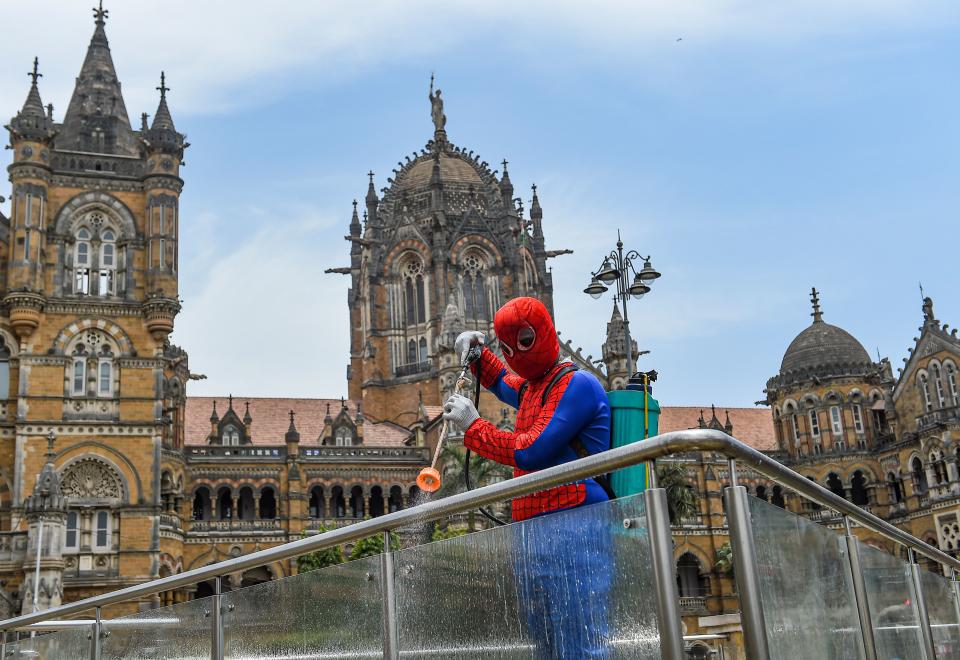 Social worker Ashok Kurmi, dressed as fictional superhero Spider Man, sanitises the area around Chhatrapati Shivaji Maharaj Terminus, during a COVID-induced lockdown to curb the spread of coronavirus, in Mumbai, Wednesday, 21 April 2021.