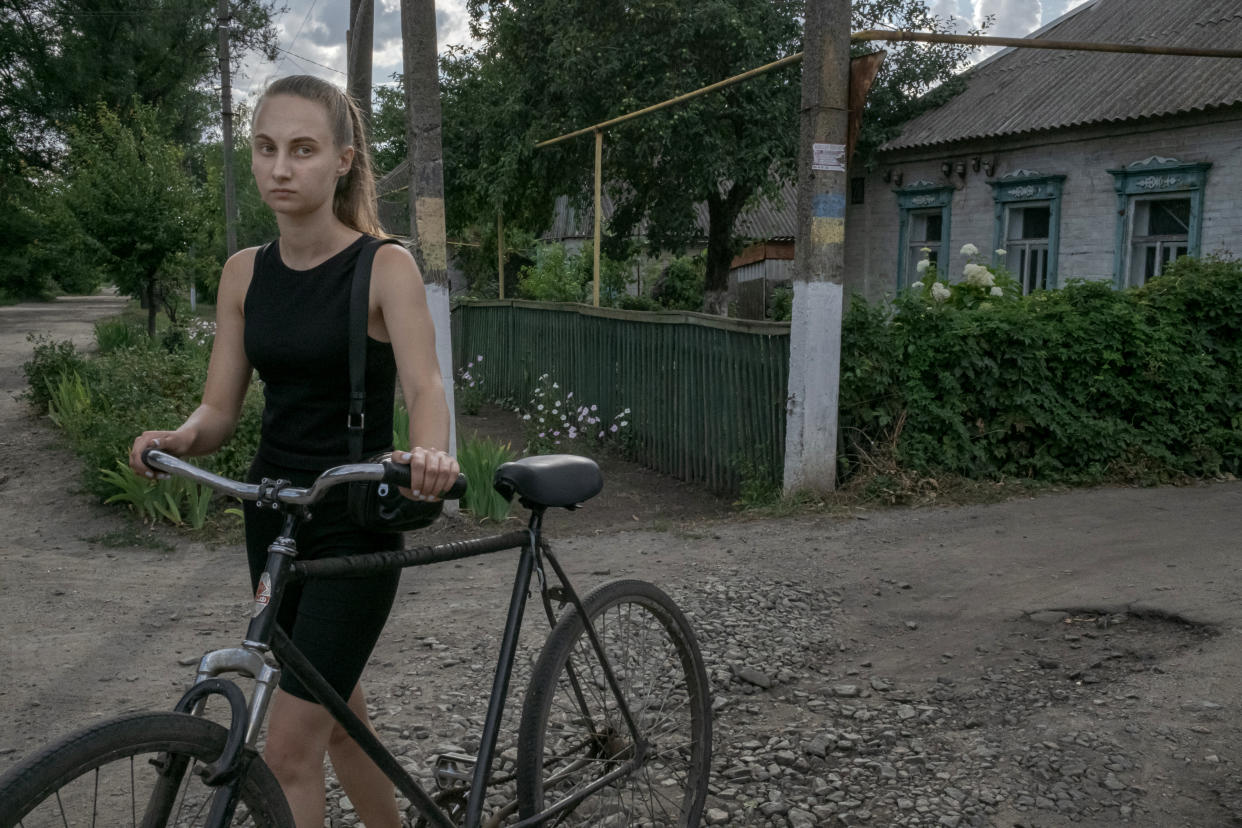 Darya Shepets, quien asegura que su hermano Vadym se había aventurado a salir para conseguir pañales y comida de bebé para su hijo cuando lo detuvieron las fuerzas rusas, camina con una bicicleta en Chaplyne, Ucrania, el 20 de julio de 2022. (Mauricio Lima/The New York Times)
