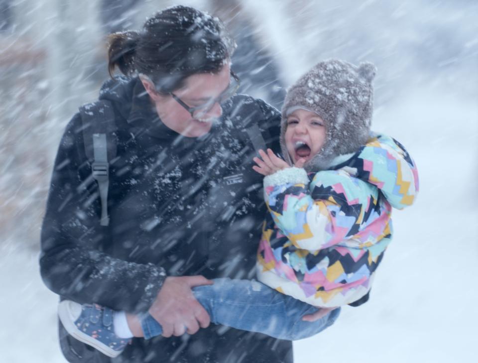 Sarah Janicek and her daughter Elaina, 1, walk to their truck during the snowfall Friday, Dec. 9, 2022, along South Howell Avenue in Milwaukee. "We're excited to build a snowman and make snow angels," Janicek said.
