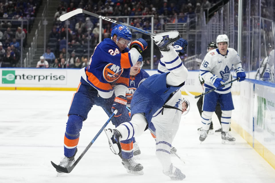 New York Islanders' Scott Mayfield (24) checks Toronto Maple Leafs' Matthew Knies, front right, as Leafs' Mitchell Marner (16) watches during the first period of an NHL hockey game Thursday, Jan. 11, 2024, in Elmont, N.Y. (AP Photo/Frank Franklin II)