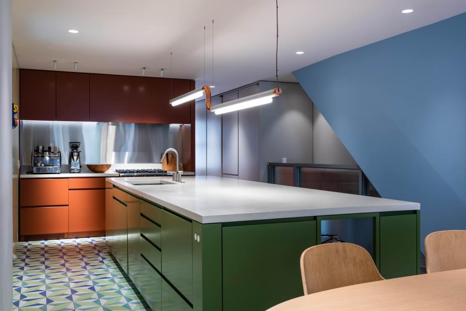 The color-blocked volumes visually differentiate the space. “We wanted the ’70s references to be a little sly, not so singular,” says Michael of the desired color palette. An ANDlight Pipeline CM3 pendant grounds the room, highlighting the central island.