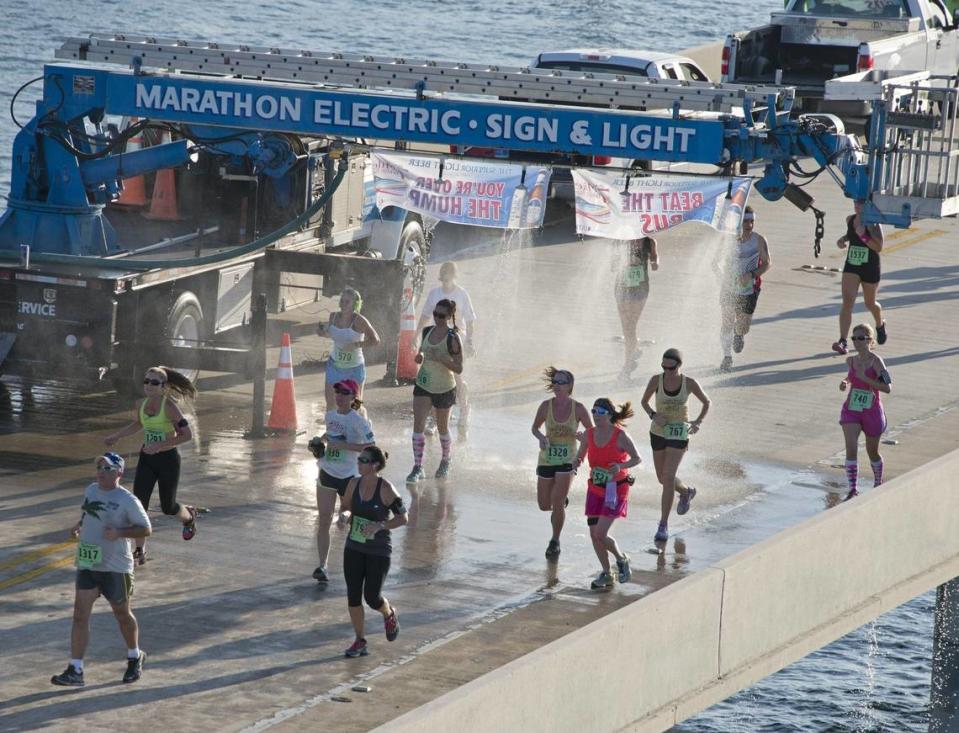 In this aerial photo provided by the Florida Keys News Bureau, contestants in the Seven Mile Bridge Run near Marathon, Fla., cool down courtesy of a series of showers Saturday, April 5, 2014. The event attracted 1,500 runners, who ran over the longest of 42 bridges over water that help comprise the Florida Keys Overseas Highway. (AP Photo/Florida Keys News Bureau, Andy Newman)