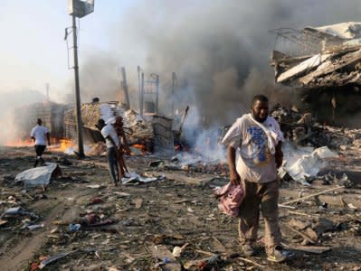 Civilians walk at the scene of an explosion in KM4 street in the Hodan district of Mogadishu. REUTERS/Feisal Omar