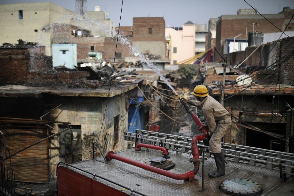 Fire fighters douse a fire at Gokul Puri tyre market which was burnt Tuesday's violence in New Delhi, India, Wednesday, Feb. 26, 2020. At least 20 people were killed in three days of clashes in New Delhi, with the death toll expected to rise as hospitals were overflowed with dozens of injured people, authorities said Wednesday. The clashes between Hindu mobs and Muslims protesting a contentious new citizenship law that fast-tracks naturalization for foreign-born religious minorities of all major faiths in South Asia except Islam escalated Tuesday. (AP Photo/Altaf Qadri)