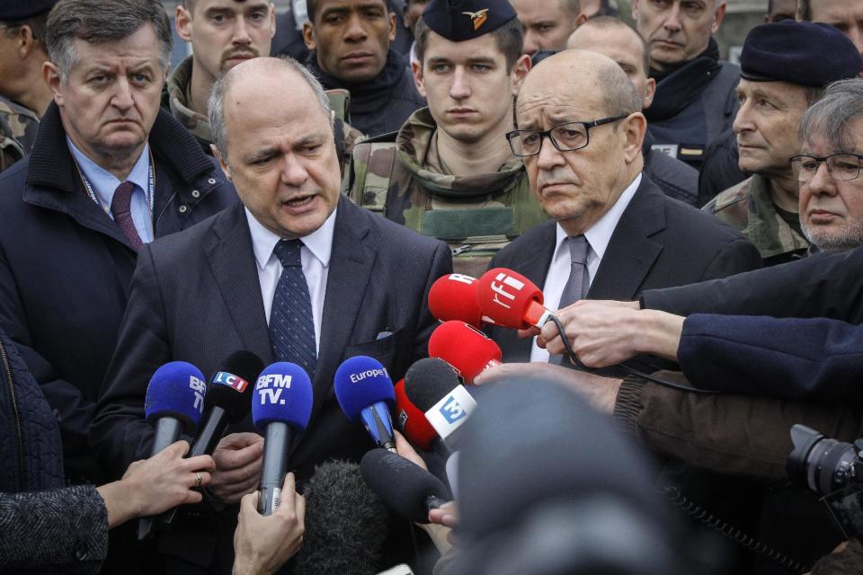 French Interior Minister Bruno le Roux, center left, and French Defense Minister Jean-Yves le Drian, center right, and Paris Airports CEO Augustin de Romanet answer reporters at Orly airport, south of Paris, Saturday, March, 18, 2017. A man was shot to death Saturday after trying to seize the weapon of a soldier guarding Paris' Orly Airport, prompting a partial evacuation of the terminal, police said. (AP Photo/Kamil Zihnioglu)
