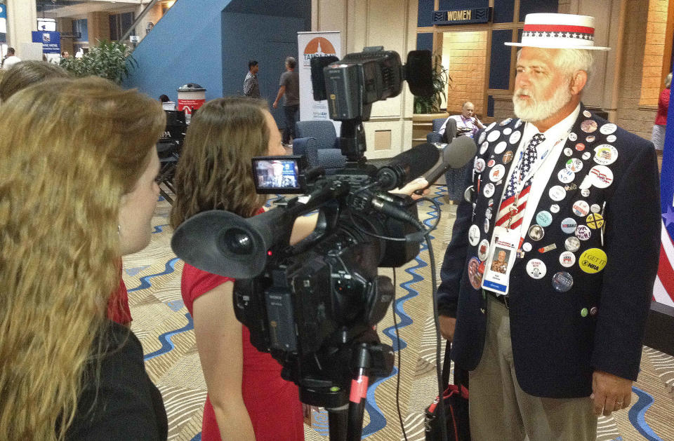 Keith Ketcham, left, sells buttons of Republican presidential nominee Mitt Romney outside the Republican National Convention on Wednesday, Aug. 29, 2012, in Tampa, Fla. While buttons are seen at the convention, they are far from ubiquitous, and the days when delegates were littered with partisan messages from seemingly head to toe appear to be long past. (AP Photo/Peter Prengaman)