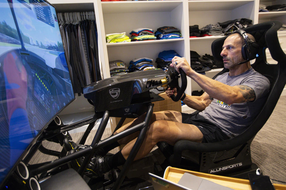 IndyCar driver Tony Kanaan, of Brazil, practices on his racing simulator in his home in Indianapolis, Saturday, March 28, 2020. Kanaan, along with other IndyCar drivers and NASCAR's Jimmie Johnson will compete in the series' inaugural virtual racing event Saturday. (AP Photo/Michael Conroy)