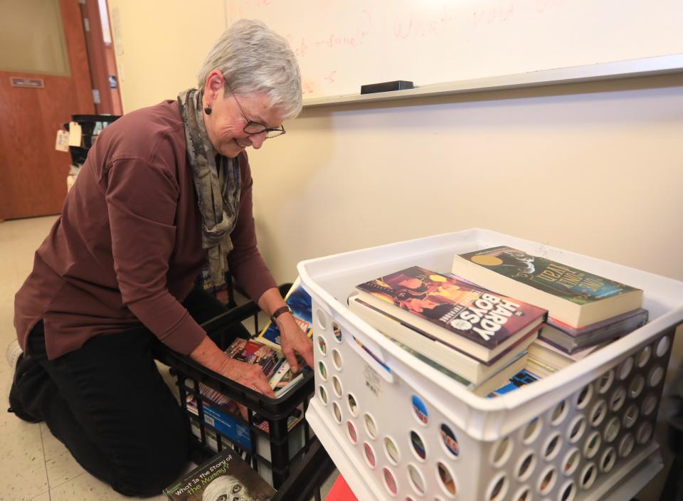 Maureen Trembly of the Poughkeepsie Branch of the American Association of University Women sorts crates of books for their Holiday Helping Hand project, Leading to Reading at the United Methodist Church in Hude Park on November 29, 2023.