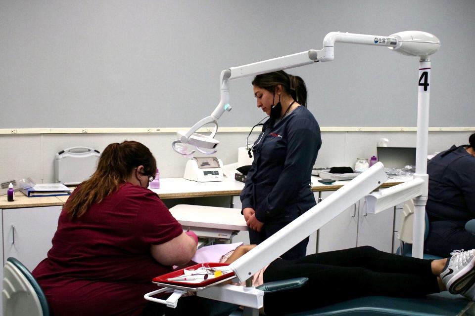 Brook Horner (left) assists Salina Tech first-year dental hygiene student Liliana Montes (right) with a cleaning.