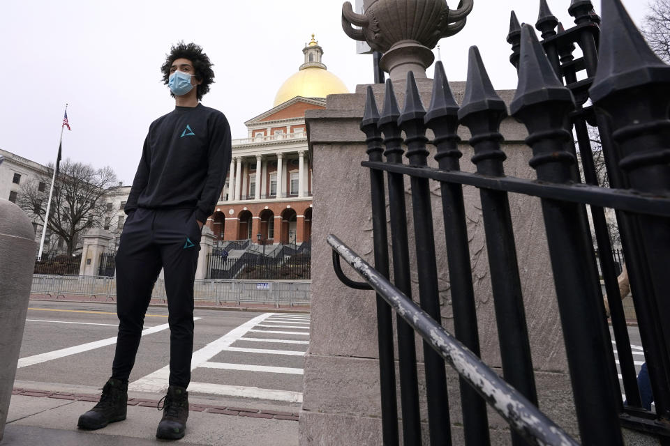 Isaac Smith, of Boston, speaks to a reporter near the Massachusetts Statehouse in Boston about the new incoming administration, Wednesday, Jan. 20, 2021. Smith, a 21-year-old Harvard University student, said he voted for Biden and was excited for what's to come. "No matter which way you look at it, it's historic. Things are going to change," he said. (AP Photo/Elise Amendola)