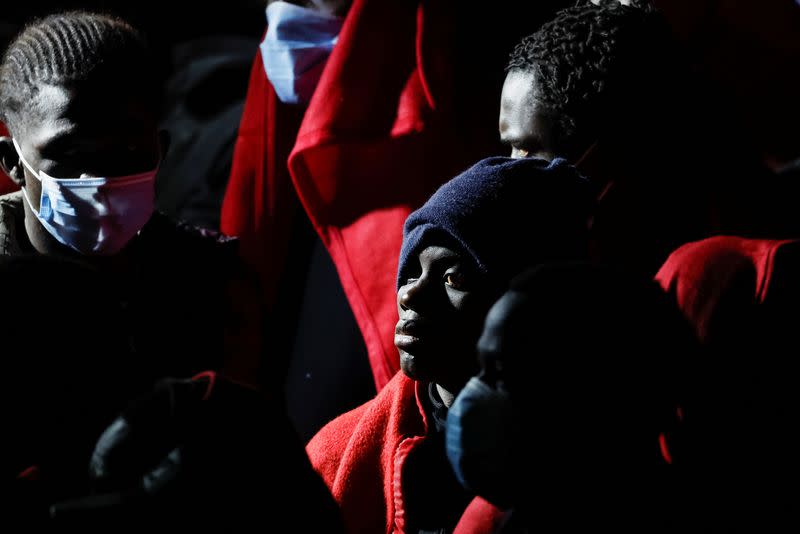 Migrants wait to disembark from a Spanish coast guard vessel, in the port of Arguineguin