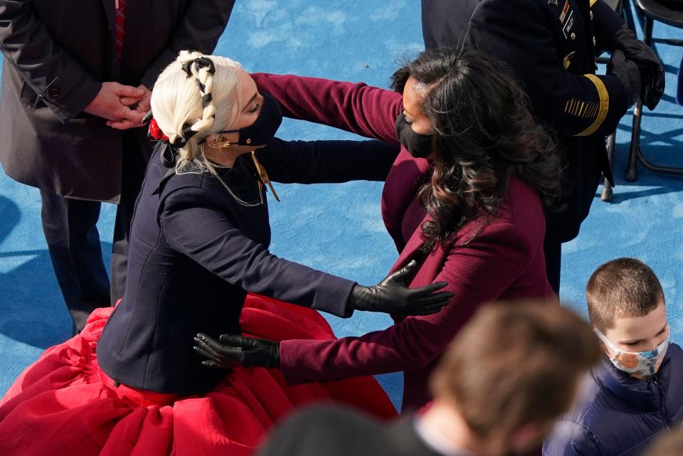 Lady Gaga and former first lady Michelle Obama embrace after after the 59th Presidential Inauguration on January 20, 2021, at the US Capitol in Washington, DC. - Joe Biden was sworn in as the 46th president of the US. 