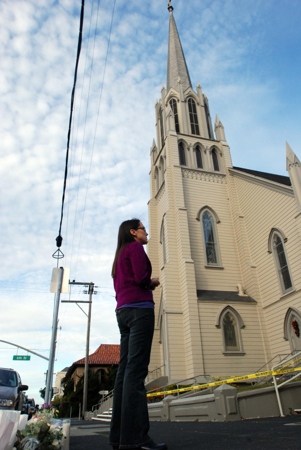 Laurie Lynch of Arcata, Calif., prays the rosary on Thursday, Jan. 2, 2014, outside St. Bernard Catholic Church in Eureka, Calif, where the Rev. Eric Freed was found slain in the rectory on New Year's Day. Gary Lee Bullock, 43, of Redway, Calif., was taken into custody by Humboldt County deputies in the killing of Freed, according to a statement by Eureka police. (AP Photo/Jeff Barnard)