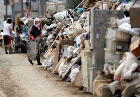 Local residents try to clear mud and debris at a flood affected area in Mabi town in Kurashiki, Okayama Prefecture, July 13, 2018. REUTERS/Issei Kato