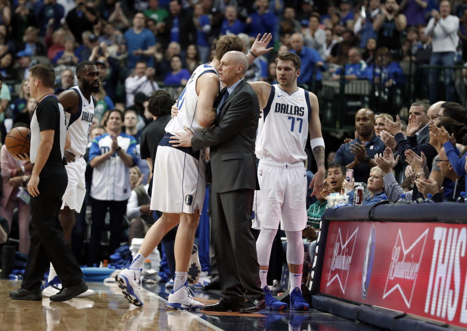 Dallas Mavericks forward Dirk Nowitzki (41) gets a hug from head coach Rick Carlisle as Luka Doncic (77) waits to greet Nowitzki at the bench after Nowitkzi sunk a basket in the first half of an NBA basketball game against the New Orleans Pelicans in Dallas, Monday, March 18, 2019. With the basket, Nowitzki became the NBA's sixth-leading scorer. (AP Photo/Tony Gutierrez)