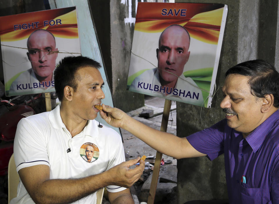 Indian friends of Kulbhushan Jadhav, share sweets as they celebrate verdict of International Court of Justice in Mumbai, India, Wednesday, July 17, 2019. The United Nations' highest court has ordered that Pakistan stay the execution of Jadhav, an alleged Indian spy and ordered that his case be reviewed after agreeing with India's contention that his rights had been violated. (AP Photo/Rajanish Kakade)