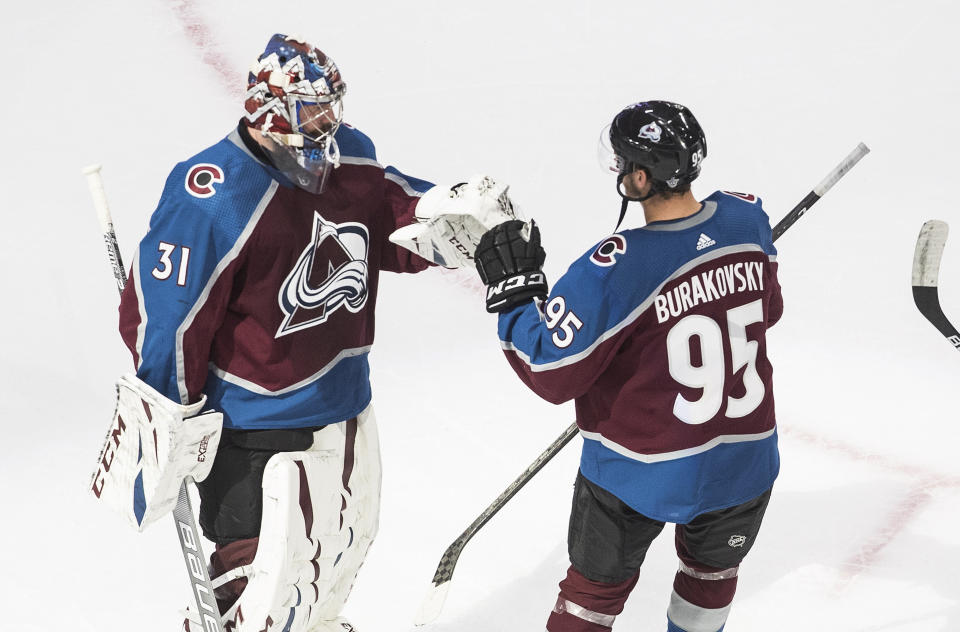 Colorado Avalanche goalie Philipp Grubauer (31) and teammate Andre Burakovsky celebrate the team's win over the Arizona Coyotes in Game 1 of an NHL hockey Stanley Cup first-round playoff series, Wednesday, Aug. 12, 2020, in Edmonton, Alberta. (Jason Franson/The Canadian Press via AP)