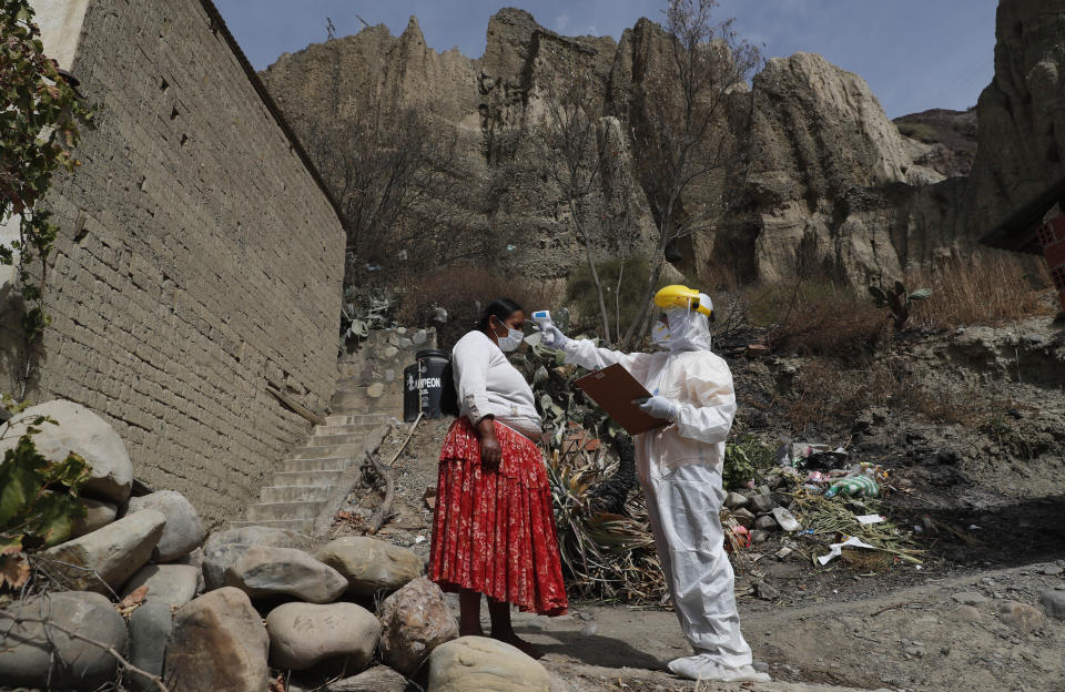 Un doctor mide la temperatura de una mujer durante una campaña de testeo de coronavirus casa por casa en Avircato, Bolivia, el martes 7 de julio de 2020. (AP Foto/Juan Karita)