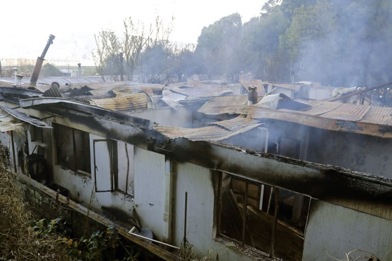 Picture released by Aton Chile showing smoke billowing from the rubble left after a fire at an nursing home, where at least ten women died, on August 14, 2018