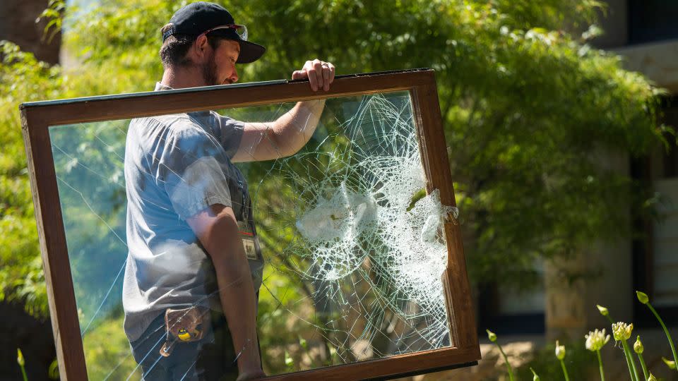 A campus maintenance worker carries a broken window from the office of Stanford University's president in Palo Alto, California, on Wednesday, June 5, 2024. - Nic Coury/AP