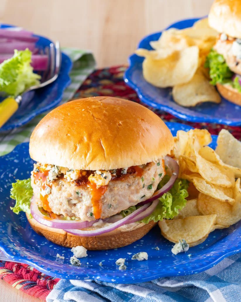 homemade chicken burger with potato chips on blue plate