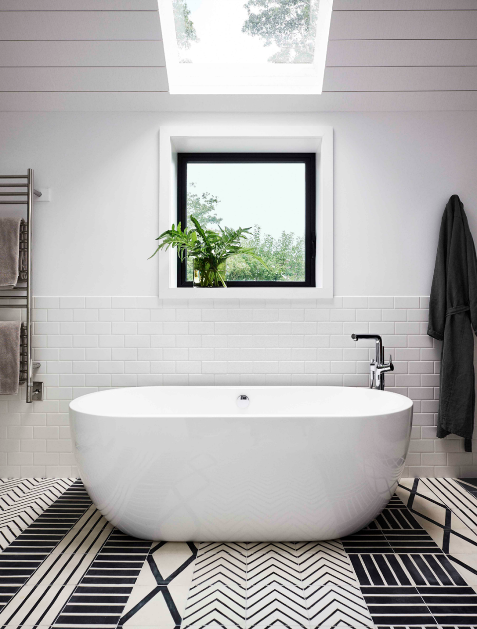 <p>These are not your grandma's white bathroom tiles. The geometric <a href="https://www.marrakechdesign.se/en/product/hook-milkkohl-12mm-tjock/" rel="nofollow noopener" target="_blank" data-ylk="slk:black and white pattern;elm:context_link;itc:0;sec:content-canvas" class="link ">black and white pattern </a>of the floor adds just the right amount of flair to this simplistic bathroom. </p>