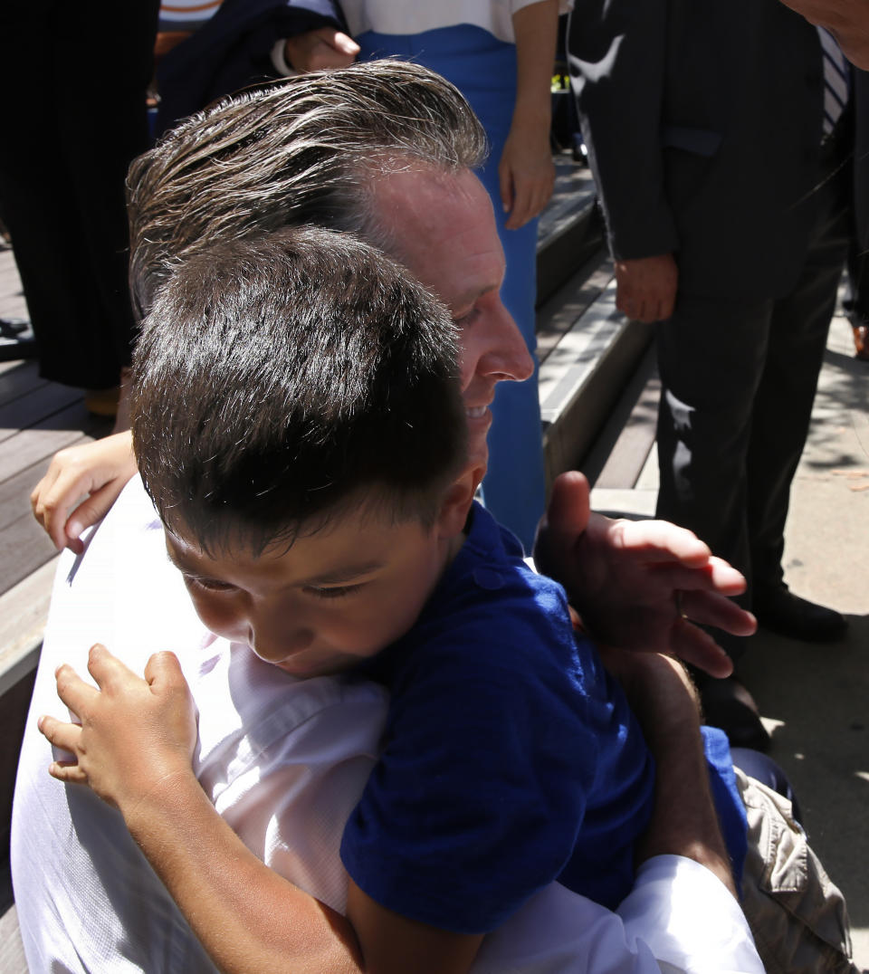 California Gov. Gavin Newsom is hugged by Rafael Amador, 5, at a rally at Sacramento City College in Sacramento, Calif., Monday, July 1, 2019. After signing several state budget trailer bills, Newsom told the gathering at the school that he vowed to continue expanding taxpayer-funded health benefits to people living in the country illegally. (AP Photo/Rich Pedroncelli)