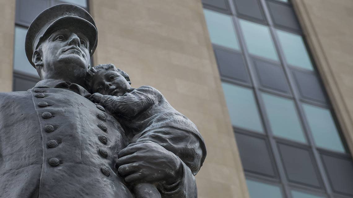 A statue of a police officer holding a child stands outside of the Kansas City Police Department Headquarters.