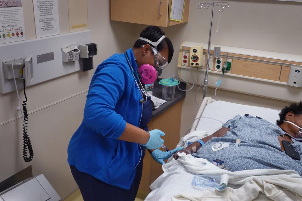 A patient receives treatment in the emergency room at Roseland Community Hospital in Chicago. About one-third of the patients that arrive in the ER at Roseland display symptoms of COVID-19. The Roseland neighborhood, on the city's far South Side, is 95% Black.