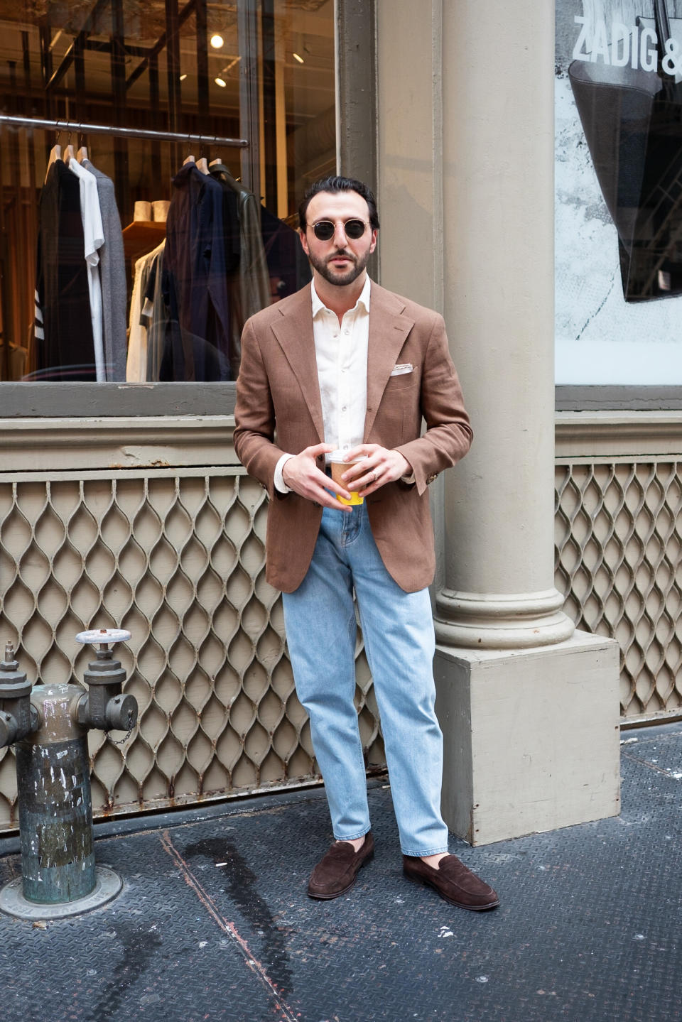 man wearing a cool blazer holding a coffee in new york