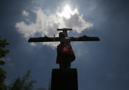 A Filipino devotee is nailed to a cross to re-enact the crucifixion of Jesus Christ in Santa Lucia village, Pampanga province, northern Philippines on Friday, April 18, 2014. Church leaders and health officials have spoken against the practice which mixes Roman Catholic devotion with folk belief, but the annual rites continue to draw participants and huge crowds. (AP Photo/Aaron Favila)