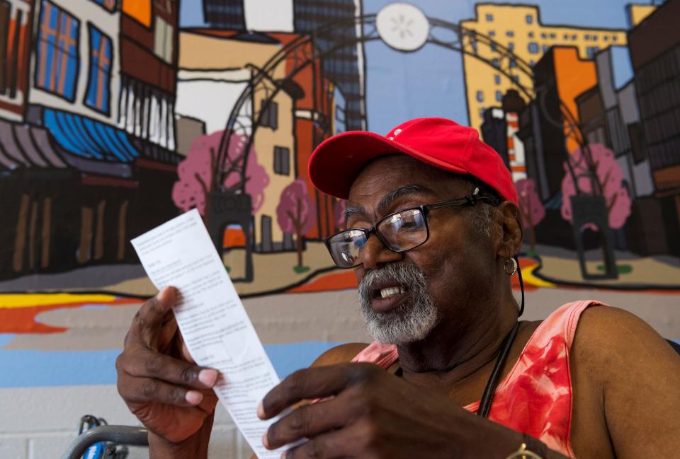 Fred Cook looks over his receipt after a grocery shopping trip to Walmart East while waiting for a METS Mobility bus to pick him up in Evansville, Ind., Tuesday morning, June 21, 2022. The 74-year-old lives in a “food desert” where access to fresh, affordable food is more limited. Cook sometimes waits an hour after calling for a bus and the roundtrip must be planned weeks in advance due to driver and bus shortages.