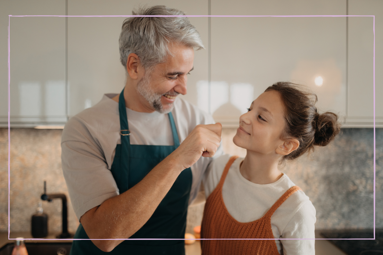  Teenage girl with his father in kitchen together. 