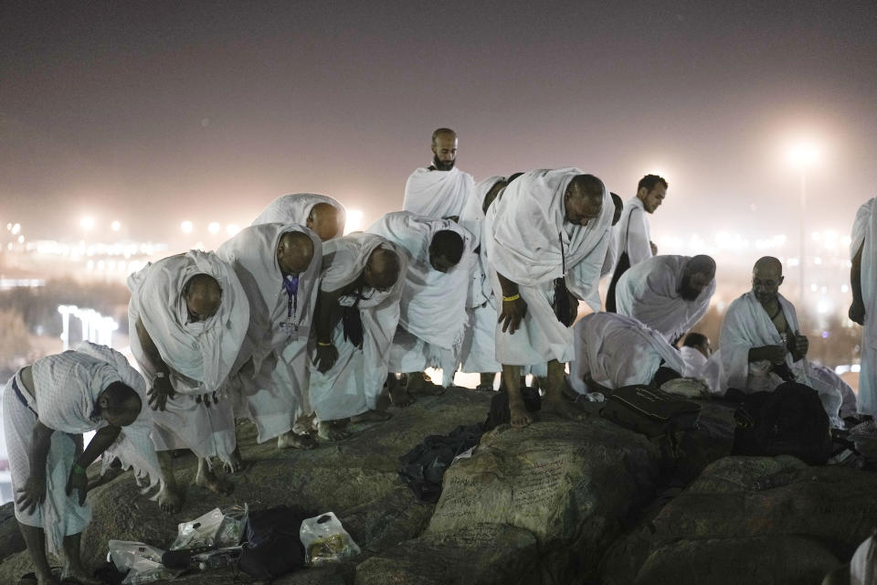 Muslim pilgrims pray on the rocky hill known as the Mountain of Mercy, on the Plain of Arafat, during the annual Hajj pilgrimage, near the holy city of Mecca, Saudi Arabia, Tuesday, June 27, 2023. Muslim pilgrims in Mecca circled the Kaaba, Islam's holiest site, and then converged on a vast tent camp in the nearby desert, officially opening the annual Hajj pilgrimage on Monday, returning to its full capacity for the first time since the coronavirus pandemic. (AP Photo/Amr Nabil)