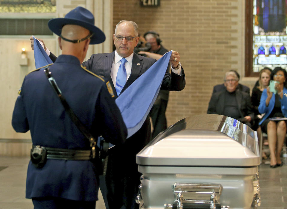Louisiana Governor John Bel Edwards places a state flag onto the casket during a Celebration of Life Interfaith Service for former Louisiana Gov. Kathleen Babineaux Blanco, at St. Joseph Cathedral in Baton Rouge, La., Thursday, Aug. 22, 2019. Thursday was the first of three days of public events to honor Blanco, the state's first female governor who died after a years long struggle with cancer.(AP Photo/Michael Democker, Pool)