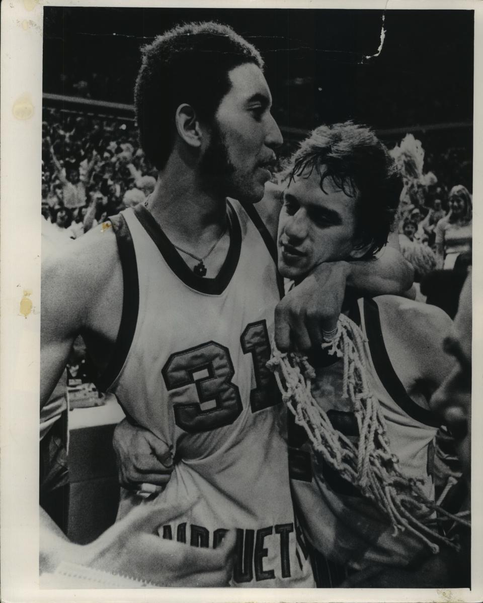 Senior forward Bo Ellis and junior guard Jim Boylan of Marquette exchanged congratulatory hugs while Ellis displayed a souvenir net after Marquette's national championship victory over North Carolina in 1977.