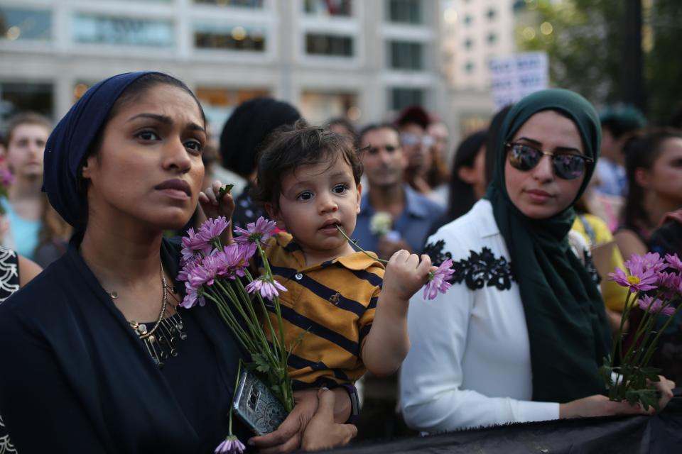 People hold flowers during the vigil in Union Square in New York City.&nbsp;