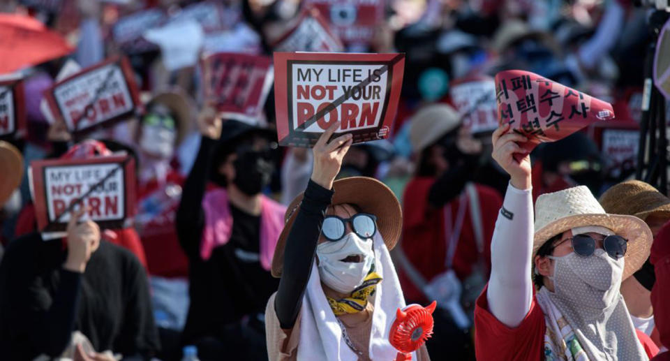 Women can be seen on the streets of Seoul protesting against spycams, holding banners that say, 'My life is not your porn'.