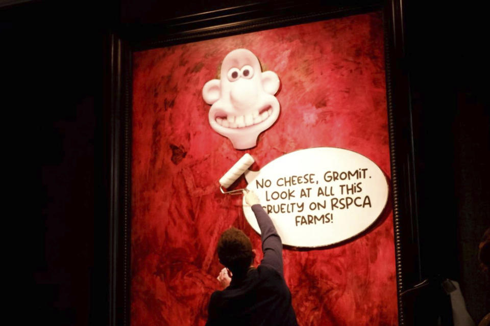 En esta foto, publicada por Animal Rising, un activista pega una imagen de un personaje llamado Wallace, de la serie humorística "Wallace and Gromit", sobre un retrato del rey británico Carlos III en la galería Philip Mould de Londres, el martes 11 de junio de 2024. (Animal Rising vía AP)