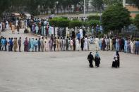 Residents line up to receive a vaccine against COVID-19 at a vaccination facility in Karachi