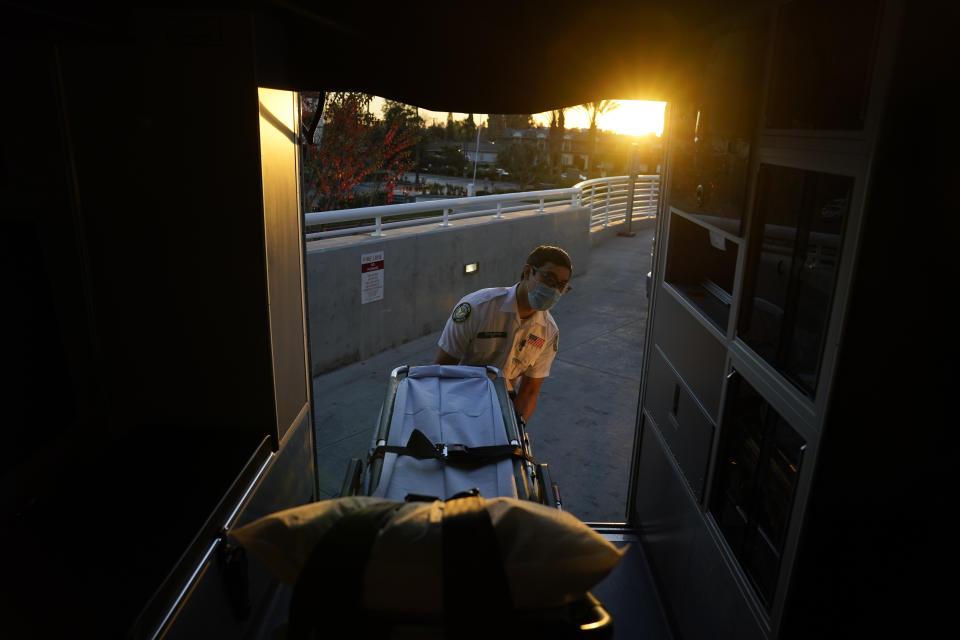 Emergency medical technician Thomas Hoang, 29, of Emergency Ambulance Service, loads a gurney into an ambulance after transporting a patient to an emergency room in Fullerton, Calif., Saturday, Jan. 9, 2021. (AP Photo/Jae C. Hong)