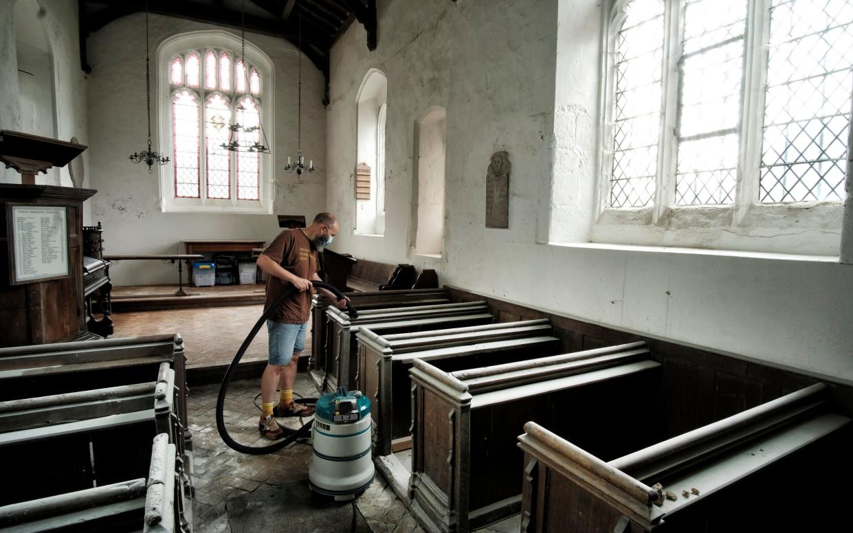 Volunteers clean up after St Mary Magdalene Caldecote in Hertfordshire was vandalised - John Robertson for The Telegraph