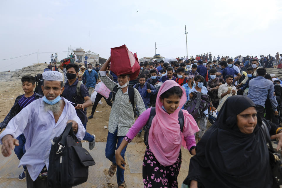 Thousands of people leaving for their native places to celebrate Eid-al-Fitr rush to the Mawa ferry terminal ignoring risks of coronavirus infection in Munshiganj, Bangladesh, Thursday, May 13, 2021. (AP Photo/Mahmud Hossain Opu)