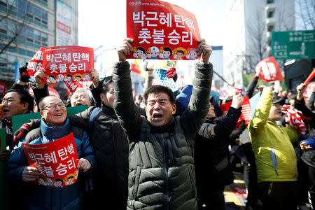 People celebrate after hearing that President Park Geun-hye's impeachment was accepted in front of the Constitutional Court in Seoul, South Korea, March 10, 2017. REUTERS/Kim Hong-Ji