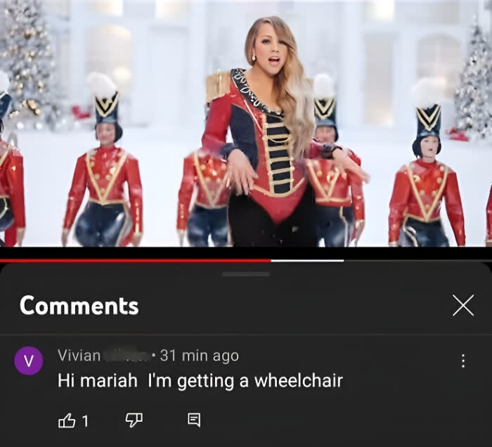 Mariah Carey in a military-style outfit performs with dancers dressed as toy soldiers. A comment below reads: "Hi mariah I'm getting a wheelchair."