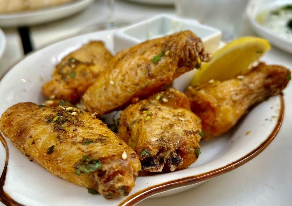 The za’atar chicken wings at NiMo Mediterranean restaurant in Tequesta are served with tzatziki and mint.