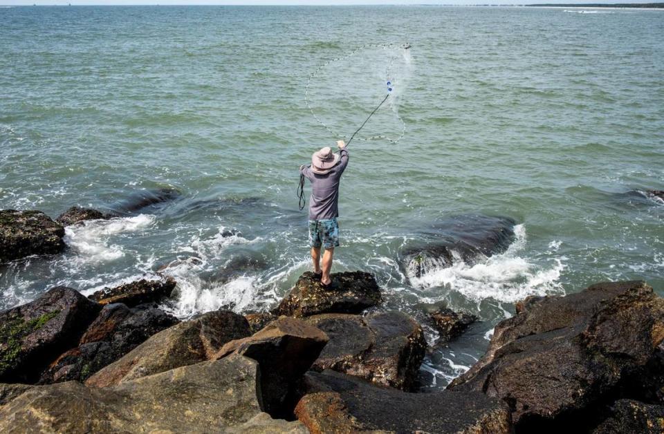 A fisherman throws a cast net to catch bait from the South Jetty in Murrells Inlet, S.C. . July 14, 2022.