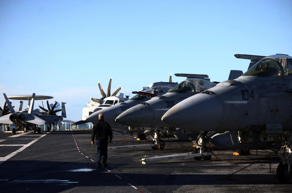 Ensign Marty Carey walks past F-18 fighter jets lined up on the flight deck of the U.S. Aircraft Carrier USS Gerald R. Ford while anchored in the Solent near Gosport, Britain, November 17, 2022. REUTERS/Henry Nicholls